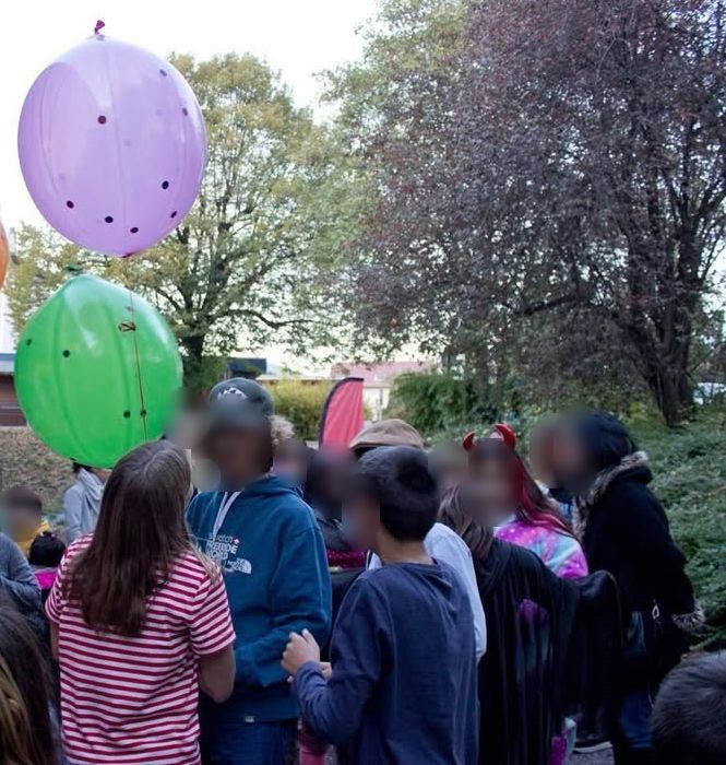 Ballons géants au-dessus des enfants, visages floutés